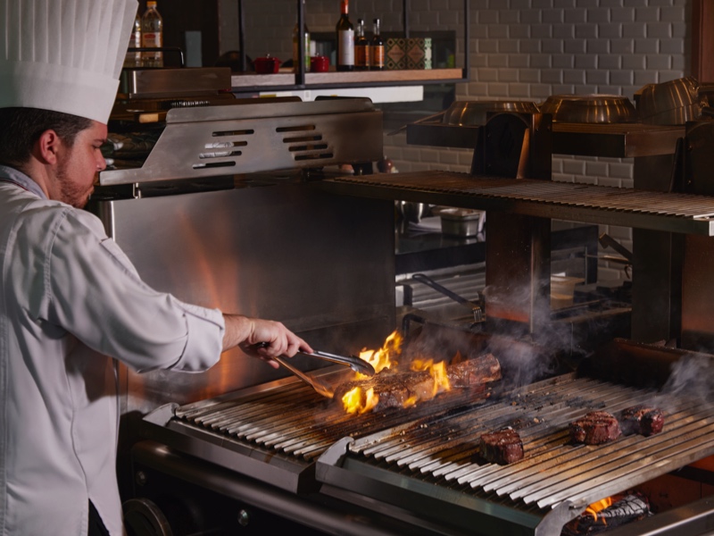 Head Chef Alejandro Garcia Martin dalam teatrikal live-fire cooking di dapur terbuka Erre & Urrechu, Gran Melià Jakarta